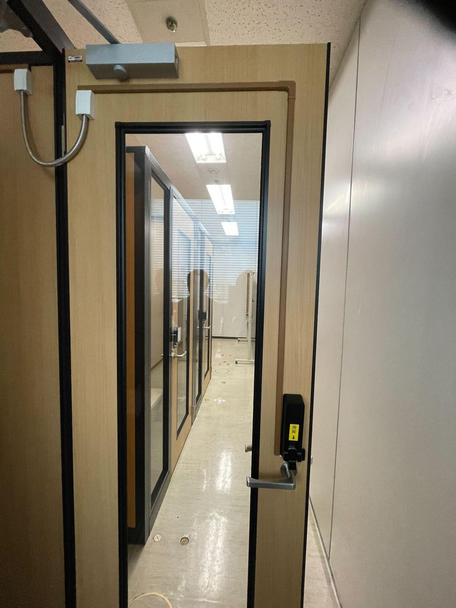 面付けの通電金具での施工例の写真。扉の上の吊元寄りに枠側と扉側の通電金具を付けてフレキシブルチューブでつなぎ、扉側の金具から扉の表面をモールでインナーユニットまで配線している